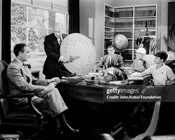 Filmmaker Cecil B DeMille and his team pictured at a story conference for the film 'Cleopatra', for Paramount Pictures, 1934.