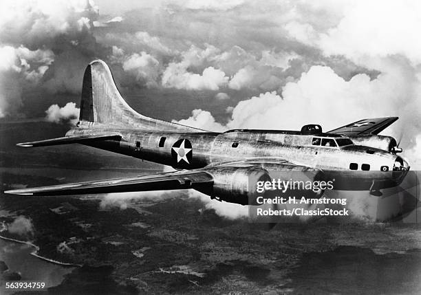 1940s WORLD WAR II AIRPLANE BOEING B-17E BOMBER FLYING THROUGH CLOUDS