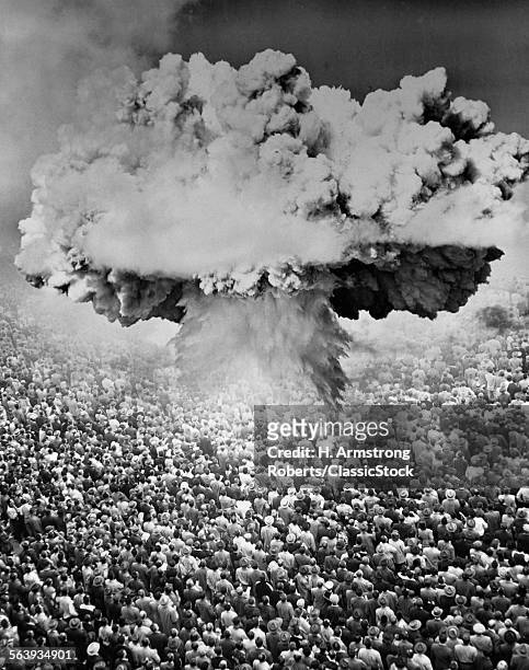 1950s 1960s ATOMIC BOMB SYMBOLIC MONTAGE MUSHROOM CLOUD OVER A VERY LARGE CROWD OF PEOPLE FACING THE EXPLOSION