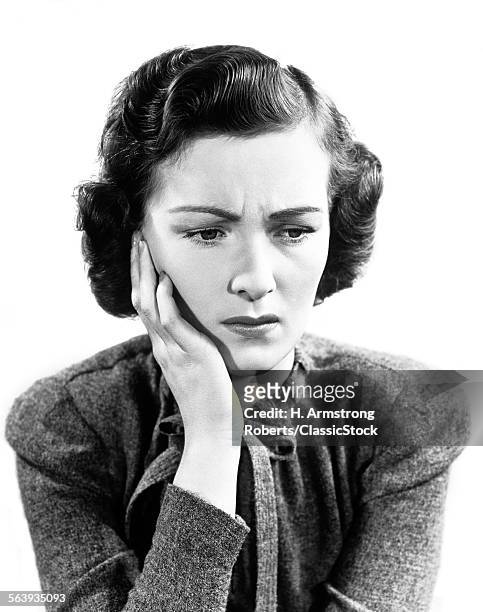 1940s WORRIED WOMAN FROWNING HOLDING HAND TO CHEEK
