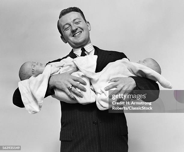 1930s PROUD FATHER SMILING PROUDLY HOLDING TWIN BABIES