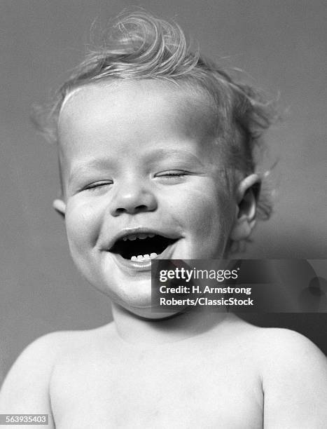 1940s PORTRAIT BABY WITH MESSY HAIR LAUGHING WITH EYES CLOSED