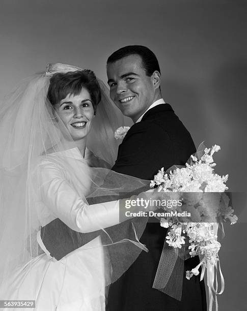 1960s WEDDING BRIDE AND GROOM PORTRAIT LOOKING AT CAMERA