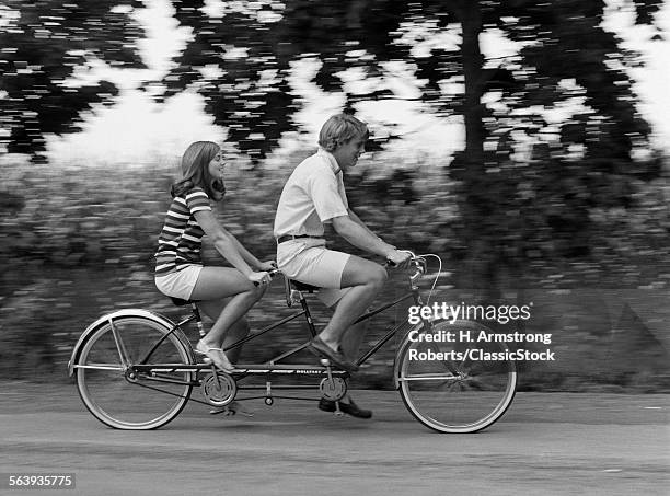 1970s TEENAGE GIRL AND BOY RIDING BICYCLE BUILT FOR TWO