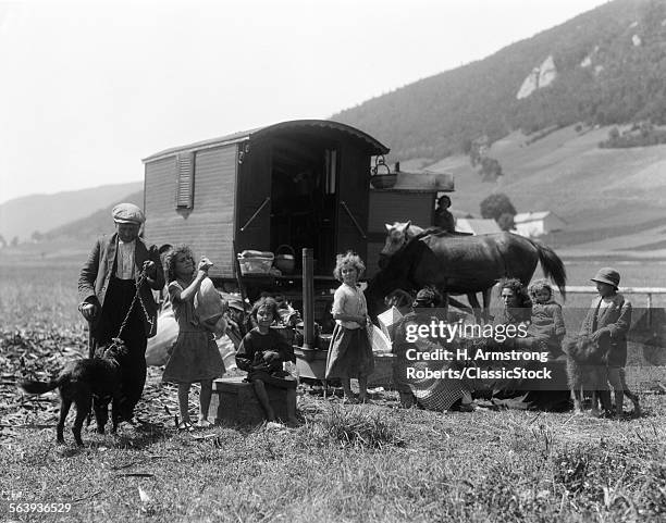 1930s SWISS NOMADS WITH GYPSY WAGON DRESSED IN PEASANT CLOTHING IN ALPINE MEADOW VALLEY