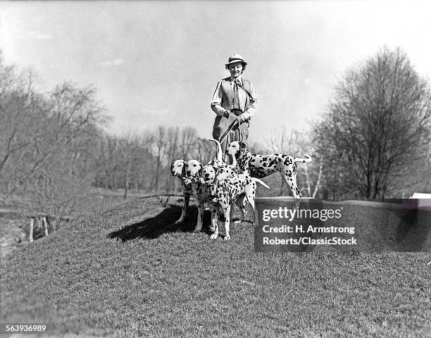 1930s SMILING WOMAN WALKING FOUR LEASHED DALMATIAN DOGS