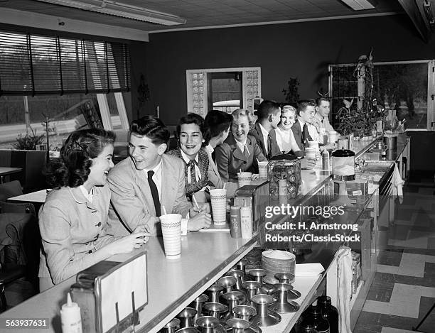1950s TEENAGERS SITTING AT SODA FOUNTAIN COUNTER