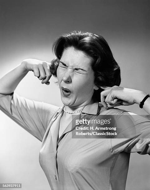 1950s WOMAN STICKING FINGERS IN EARS EYES CLOSED FUNNY FACIAL EXPRESSION