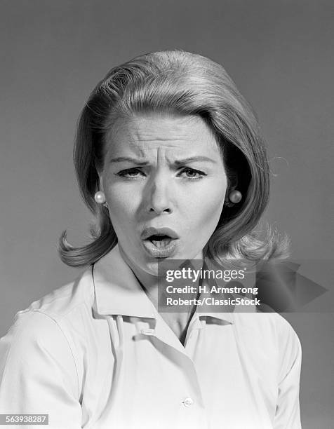 1960s WOMAN BLOND HAIR IN FLIP LOOKING AT CAMERA MOUTH OPEN ANGRY MAD FACIAL EXPRESSION