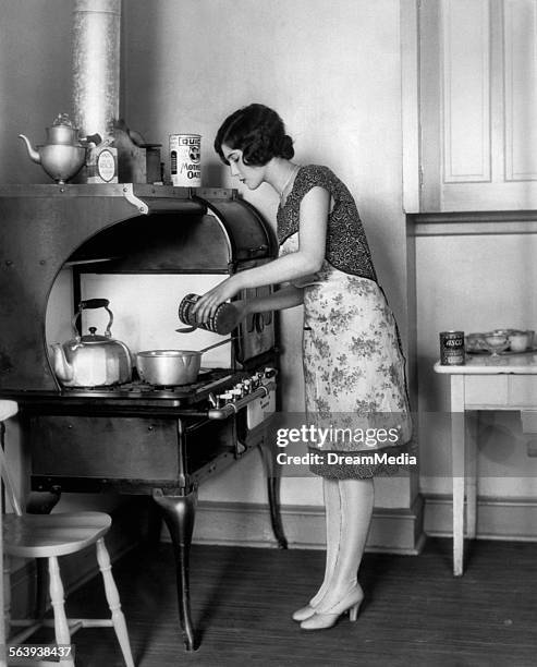 1920s HOUSEWIFE AT STOVE COOKING