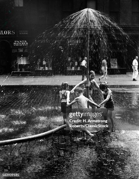 1930s INNER CITY CHILDREN PLAYING IN SPRAY FROM FIRE HYDRANT WATER SPRINKLER CANAL STREET NEW YORK CITY