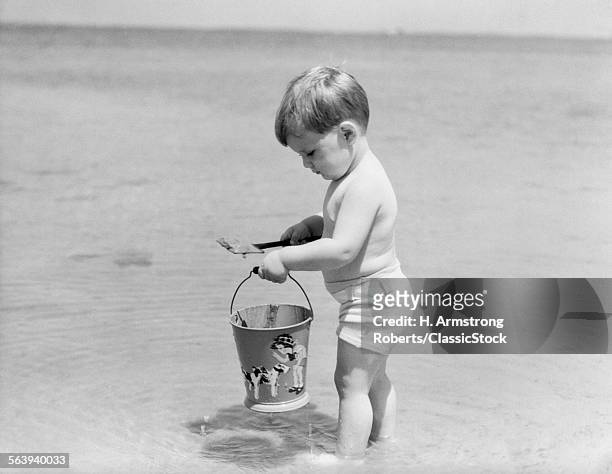 1930s 1940s BOY TODDLER ON BEACH WITH SHOVEL AND SAND PAIL BUCKET SUMMER FUN SEASHORE PLAY