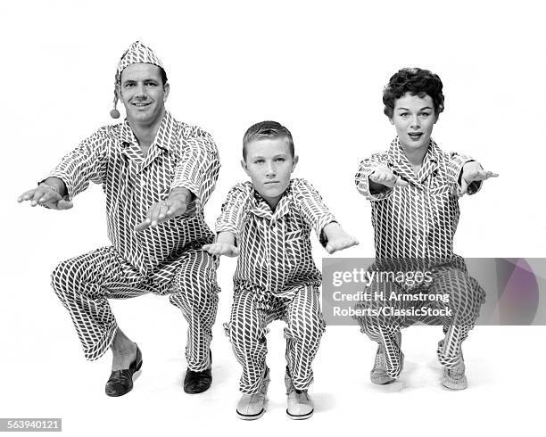 1950s FAMILY OF 3 IN MATCHING PAJAMAS DOING KNEE BENDS