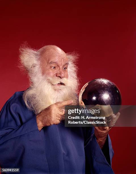 1960s BALDING WHITE HAIRED MAN IN ROBE LOOKING AT SILVER BALL HE IS HOLDING STUDIO