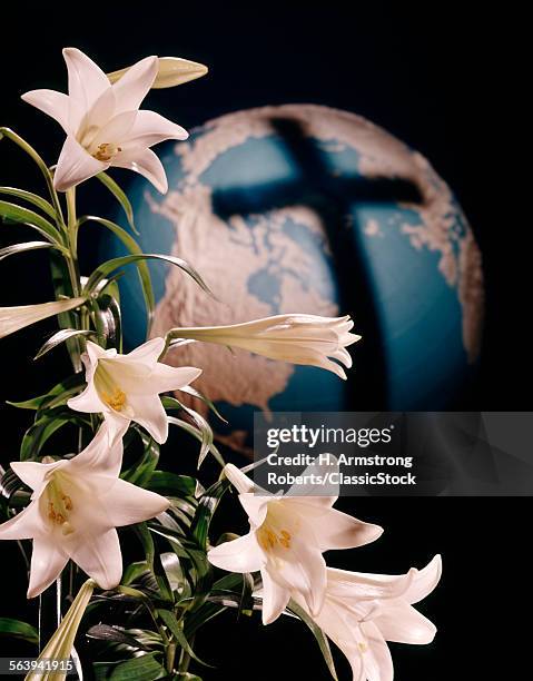 1960s EASTER LILIES AND SHADOW OF CROSS ON A GLOBE OF THE EARTH