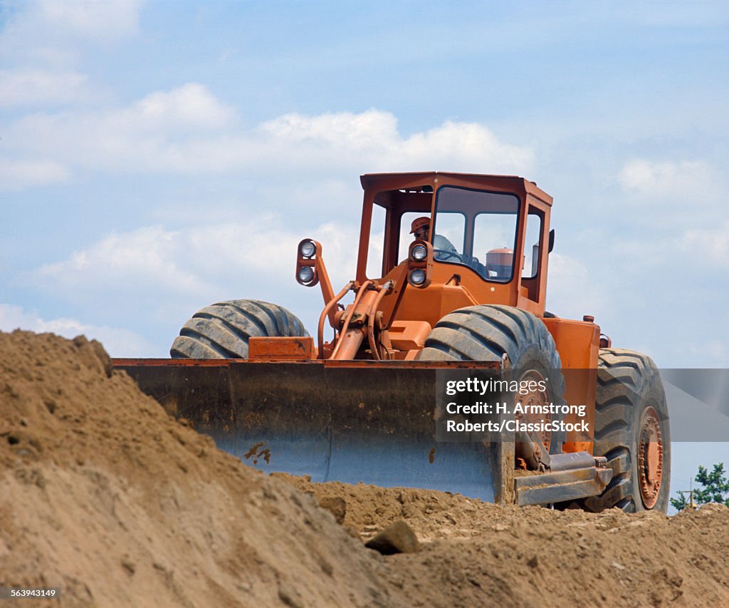 MAN OPERATING A BULL DOZER...