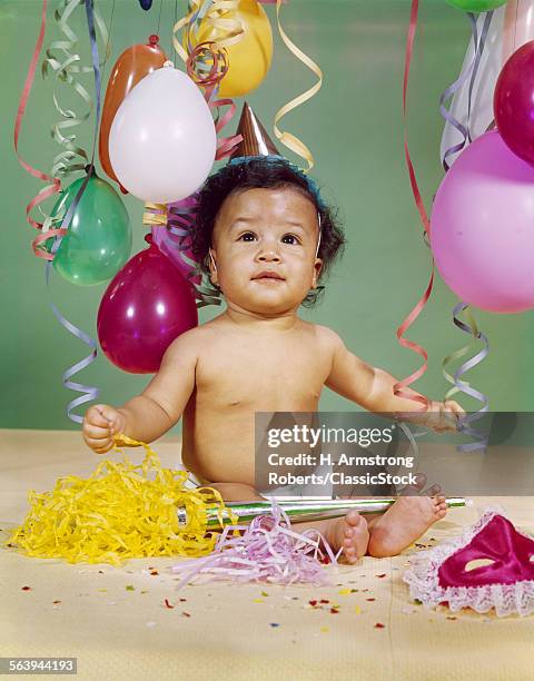 1960s AFRICAN AMERICAN BABY BOY WEARING PARTY HAT BALLOONS STREAMERS NOISEMAKER MASK