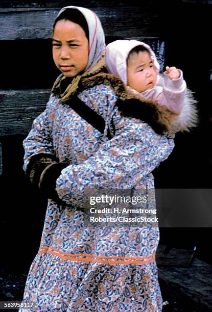 1960s INUIT MOTHER CARRYING BABY ON BACK ESKIMO NOME ALASKA NATIVE AMERICAN INDIAN GIRL KING ISLAND