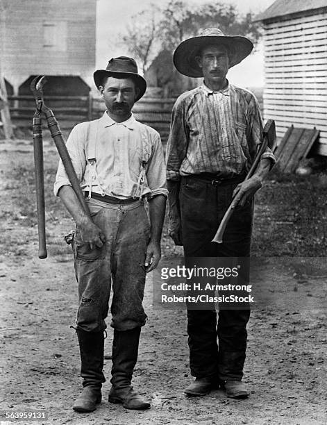 1890s 1900s 2 MEN ON FARM IN WORK CLOTHES ONE HOLDING TREE PRUNER & ONE HOLDING AX