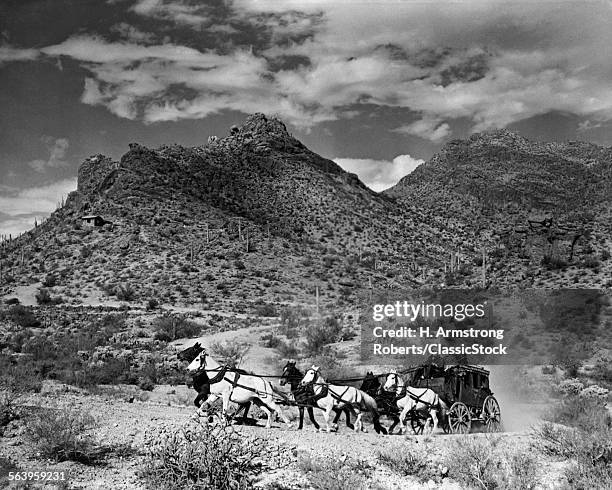 19TH CENTURY AMERICAN WEST PAIR OF MEN DRIVING STAGECOACH DRAWN BY TEAM OF SIX HORSES THROUGH RUGGED LANDSCAPE