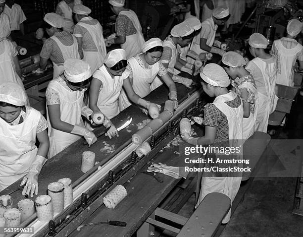 1930s GROUP OF WOMAN WORKERS WORKING IN FOOD PROCESSING PLANT SLICING PINEAPPLE PREPARING TO BE CANNED IN HONOLULU HAWAII