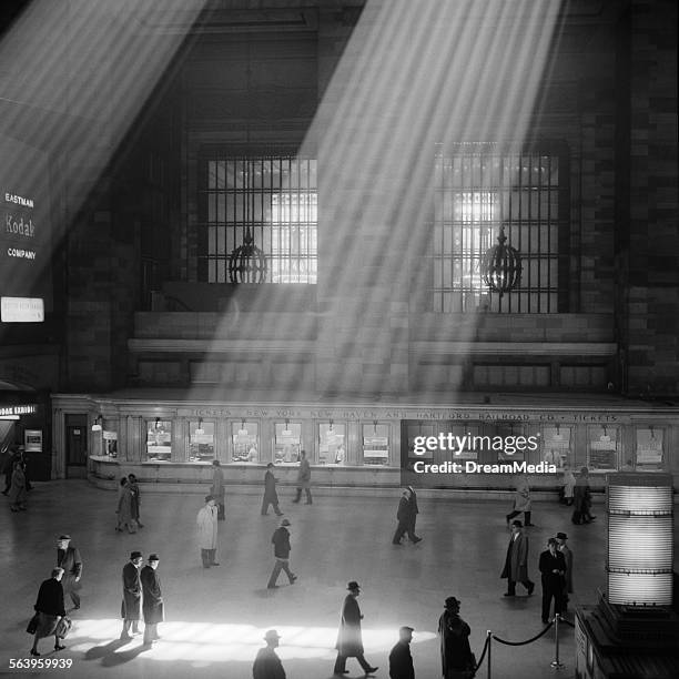 1960s CROWD WALKING THROUGH SUNBEAMS IN THE MAGNIFICENT DRAMATIC POETIC CAVERNOUS ATRIUM OF GRAND CENTRAL STATION NEW YORK CITY