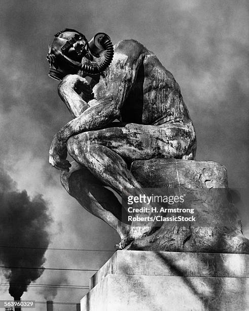 1970s BRONZE STATUE OF RODIN'S THINKER WEARING GAS MASK WITH SMOKE STACKS BILLOWING IN BACKGROUND