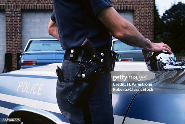 1970s DETAIL OF POLICE OFFICERS HIP WITH BELT GUN AND HOLSTER