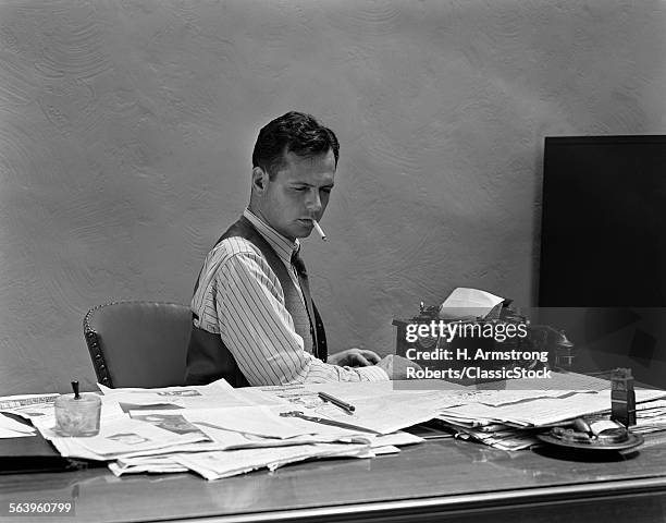 1930s 1940s BUSY MAN IN SHIRT SLEEVES BEHIND OFFICE DESK WORKING AT TYPEWRITER SMOKING CIGARETTE