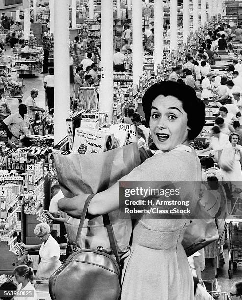 1960s HOUSEWIFE LOOKING AT CAMERA HOLDING GROCERY BAG SUPERIMPOSED OVER GROCERY STORE CHECK-OUT LINES