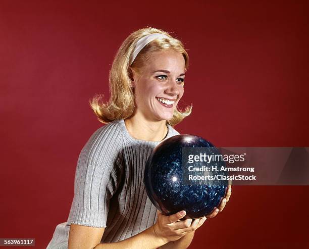 1960s YOUNG BLONDE WOMAN HOLDING BOWLING BALL WEARING BLUE SWEATER