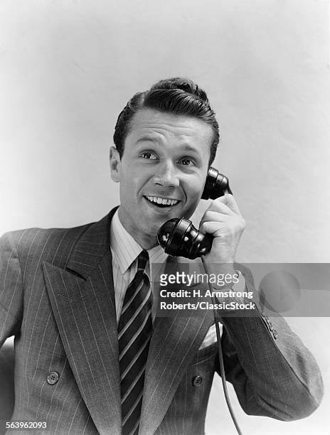 1930s MAN IN SUIT TALKING ON TELEPHONE
