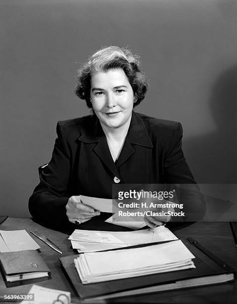 1950s WOMAN SEATED AT DESK OPENING MAIL OFFICE BUSINESS PAPERWORK