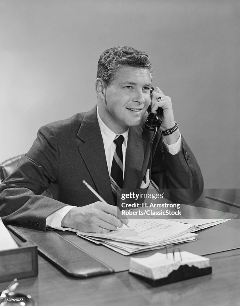 1960s BUSINESSMAN SEATED...