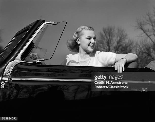 1930s 1940s SMILING PRETTY BLOND TEENAGE WOMAN SITTING IN CONVERTIBLE AUTOMOBILE DRIVER SEAT