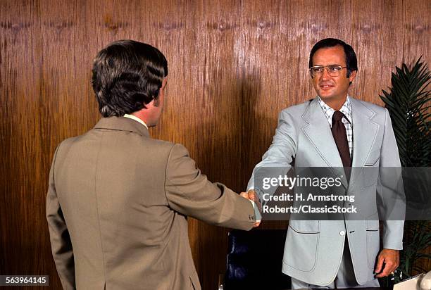 1970s TWO MEN SHAKING HANDS IN OFFICE