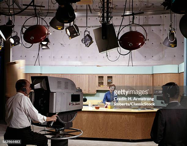 1950s 1960s CAMERA MAN AND DIRECTOR IN STUDIO KITCHEN SET SHOOTING WOMAN PERFORMING COOKING SHOW FOR TELEVISION PROGRAM