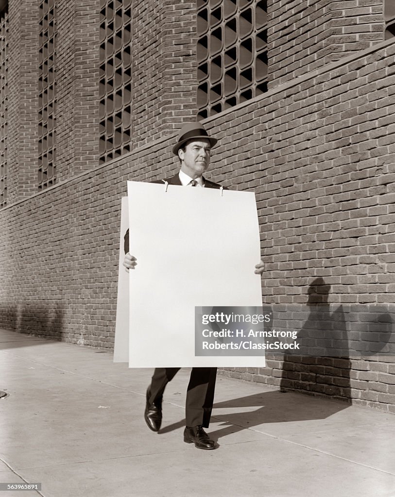 1950s BUSINESSMAN WALKING...
