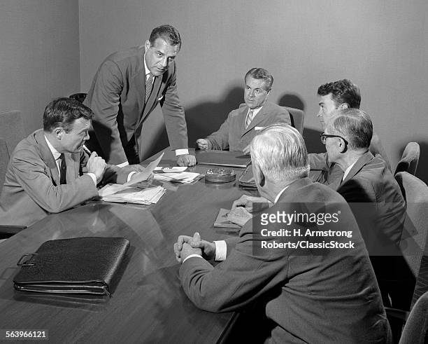 1950s SIX BUSINESSMEN EXECUTIVES AROUND A CONFERENCE TABLE TALKING
