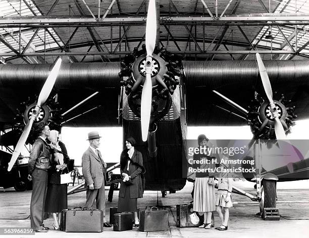 1920s 1930s GROUP OF PASSENGERS WAITING IN FRONT OF FORD TRI-MOTOR AIRPLANE