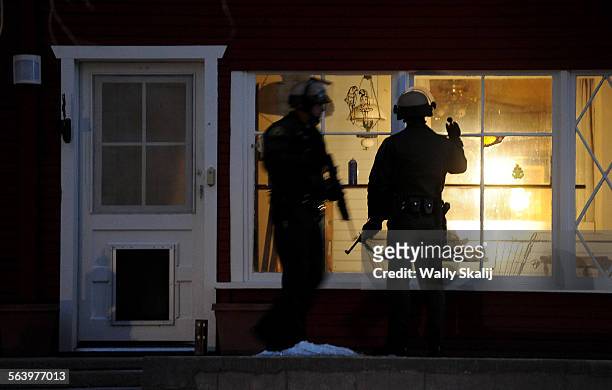 Police officers check a house along Switzerland Ave. For murder suspect Christopher Dorner in Big Bear Lake Thursday.