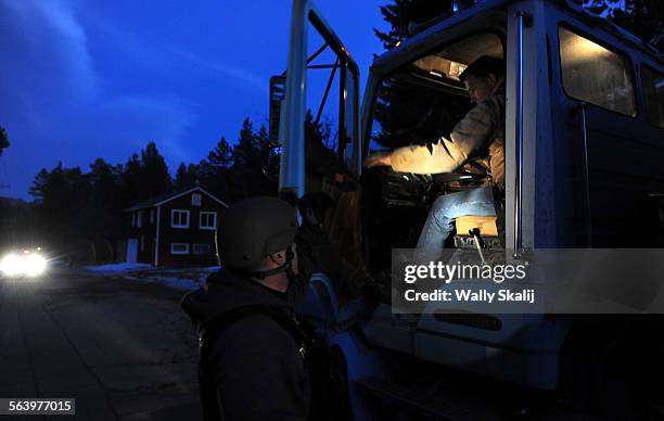 Police officer checks the cab of a truck along Switzerland Ave. For murder suspect Christopher Dorner in Big Bear Lake Thursday.