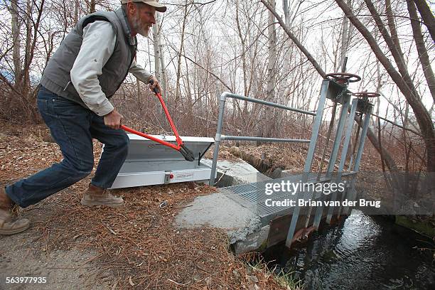 Frank Stewart shows off a bolt cutter which could be used in an emergency to cut a chain and padlock securing a concrete and steel water gate on a...