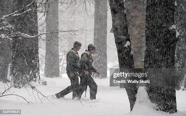 San Bernardino County Sheriff officers fight the elements near Switzerland Drive as they continue to look for murder suspect Christopher Dorner in...