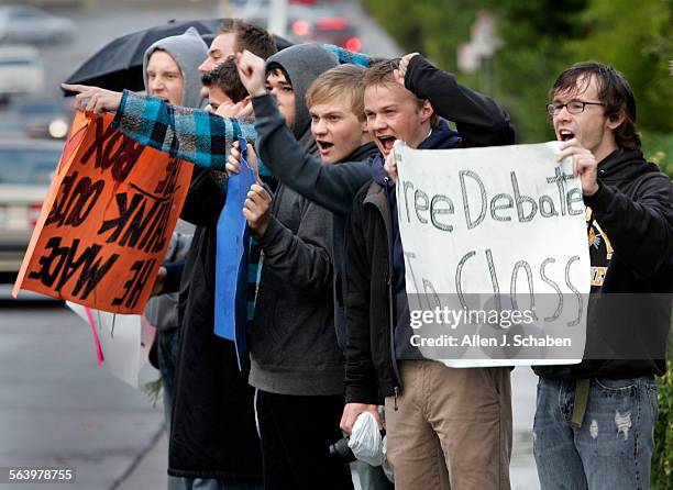 Capistrano Valley High students and alumni cheer as motorists honk their horns in support of teacher Dr. James Corbett before school Wednesday,...