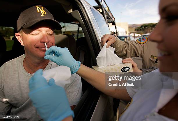 Moorpark CA. Motorists line up in their cars to get their flu shots the California way at the drive through. Ed Clark, 43 years old form Newbury...