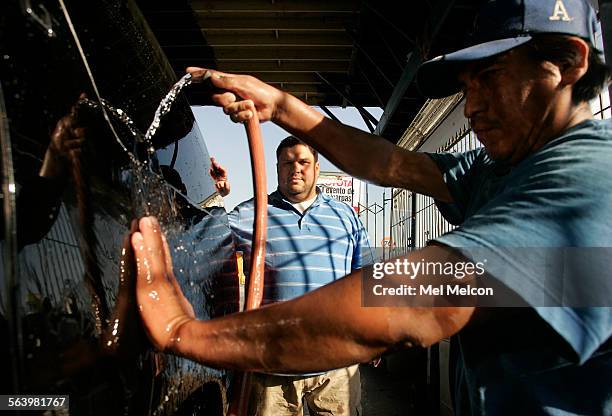 Fred Lane, background, owner of E.L.A. Car Wash, on 3rd St. In East Los Angeles, says that his business is barely surviving, hurt by the construction...