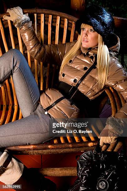 Taylor wears a Moncler "Agnes" jacket $1,003.00 at Pink Label, Los Angeles; J Brand jeans; a Prada hat; Gap gloves; a Moncler "Black Grand Coussin"...