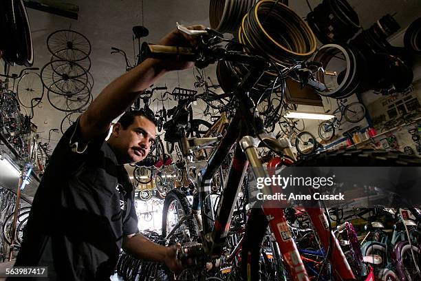 Carlos Sanchez adjusts the brakes in Dennison Cyclery on Whittier Boulevard May 13, 2008 in East Los Angeles. The shop has been in business since...