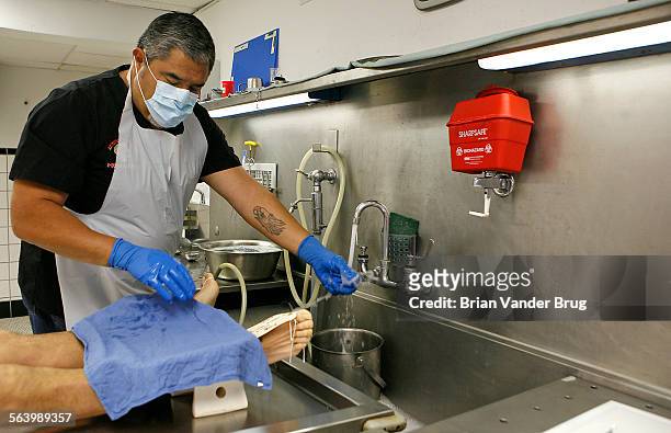 Vidal Herrera washes off his gloves during a private autopsy in his Los Angeles facility. Death has been a godsend to Vidal Herrera who founded three...